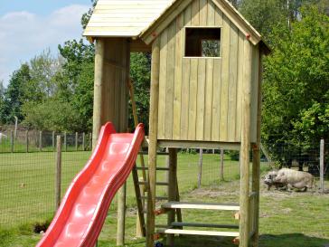 Houten speelhuis met glijbaan